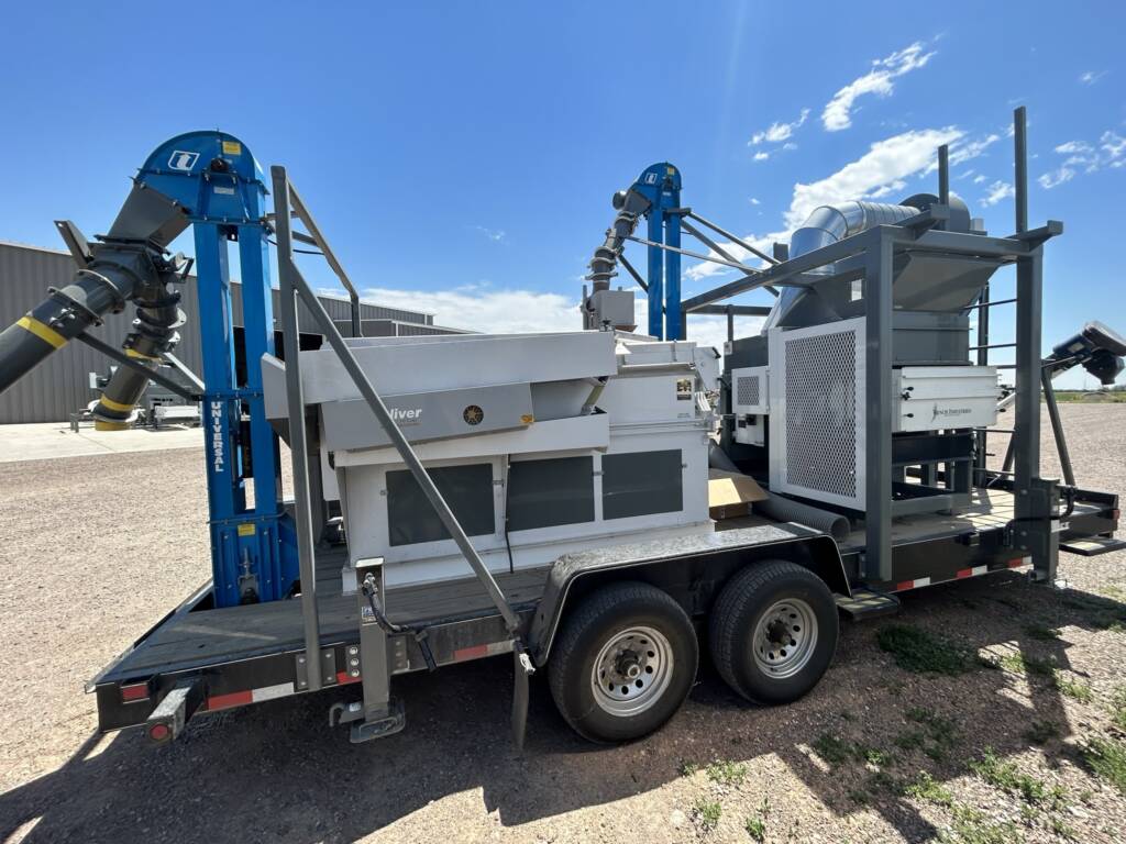 Portable on farm grain cleaning system with air screen and gravity table.